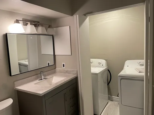 a bathroom with a sink toilet and mirror