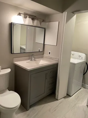 a bathroom with a sink toilet and mirror
