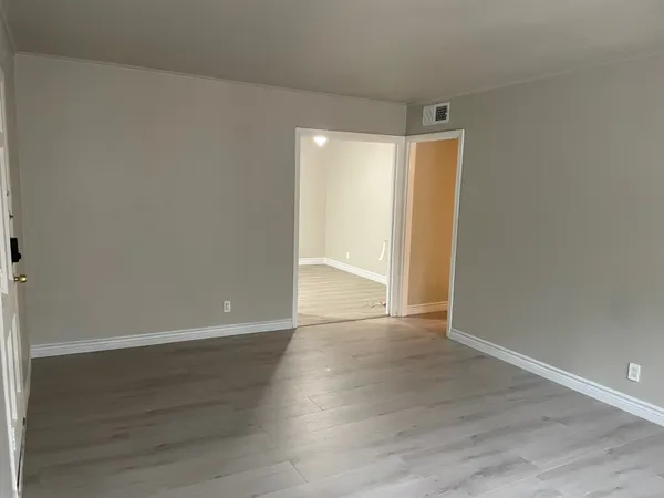 a view of an empty room with wooden floor