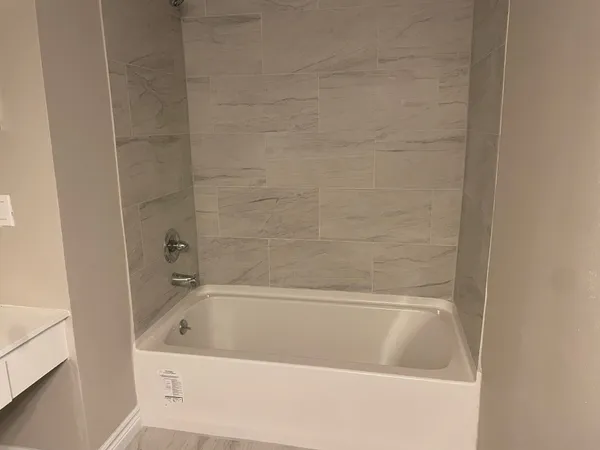a bath tub sitting next to a white sink