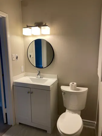 a bathroom with a toilet a sink and mirror