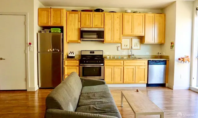 a kitchen with stainless steel appliances granite countertop a stove a sink and a refrigerator