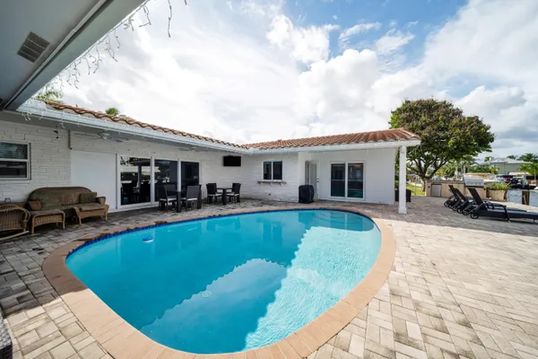 a view of a house with swimming pool and furniture