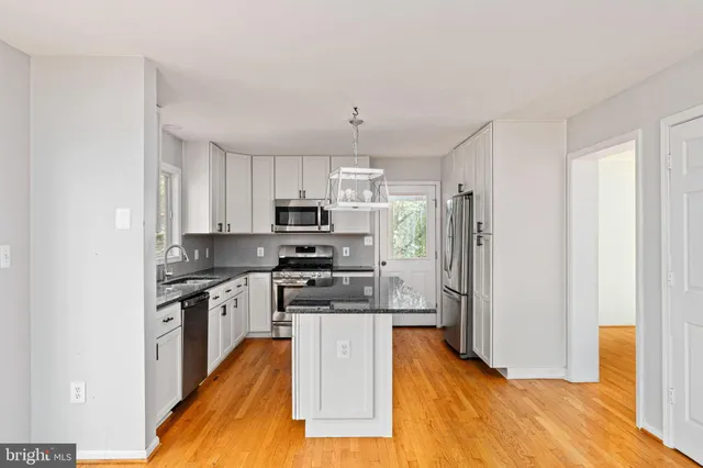 a view of a kitchen with wooden floor and a kitchen