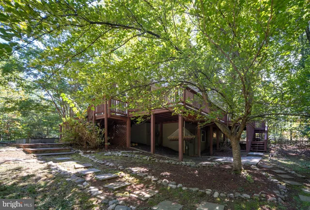 a bathroom with a toilet a sink a mirror a window and vanity