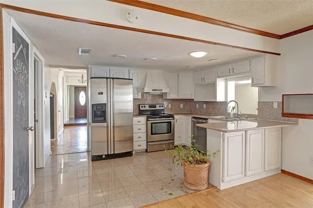 a kitchen with cabinets stainless steel appliances and a sink