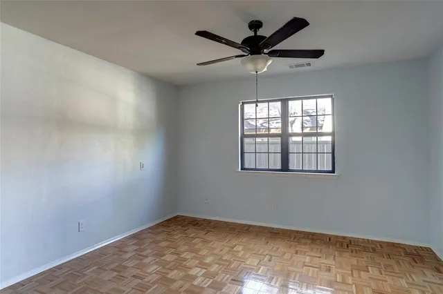 a view of a hallway with wooden floor and a ceiling fan