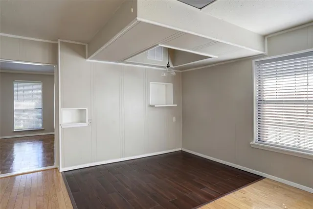 an empty room with wooden floor and sliding door