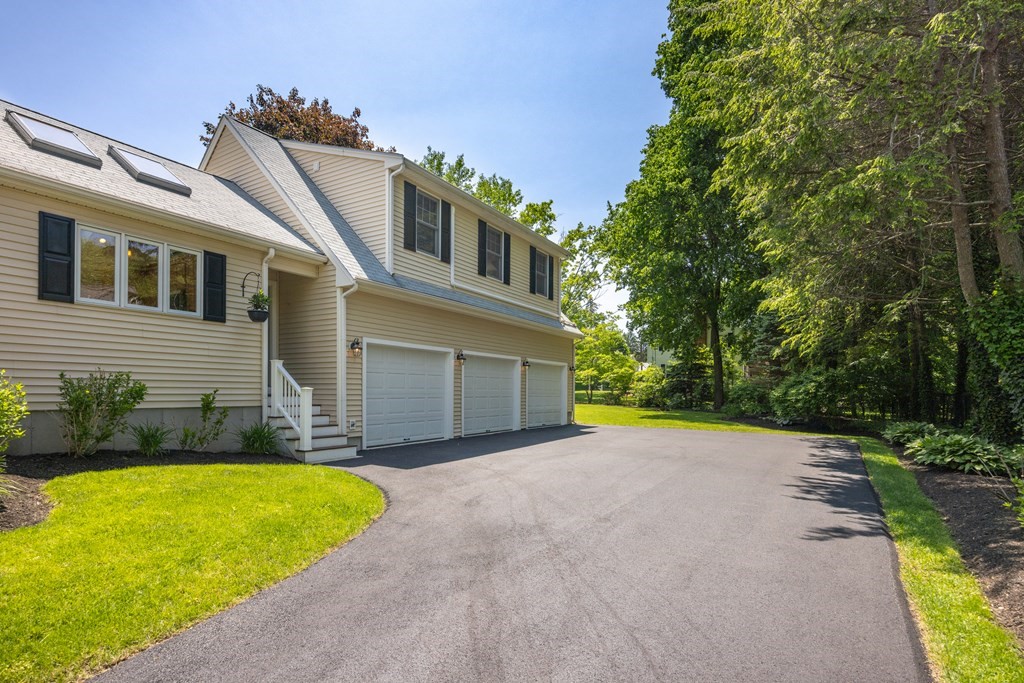 64 Reed Street Lexington, MA 02421 - Photo 3 of 12 a front view of a house with a yard and garage
