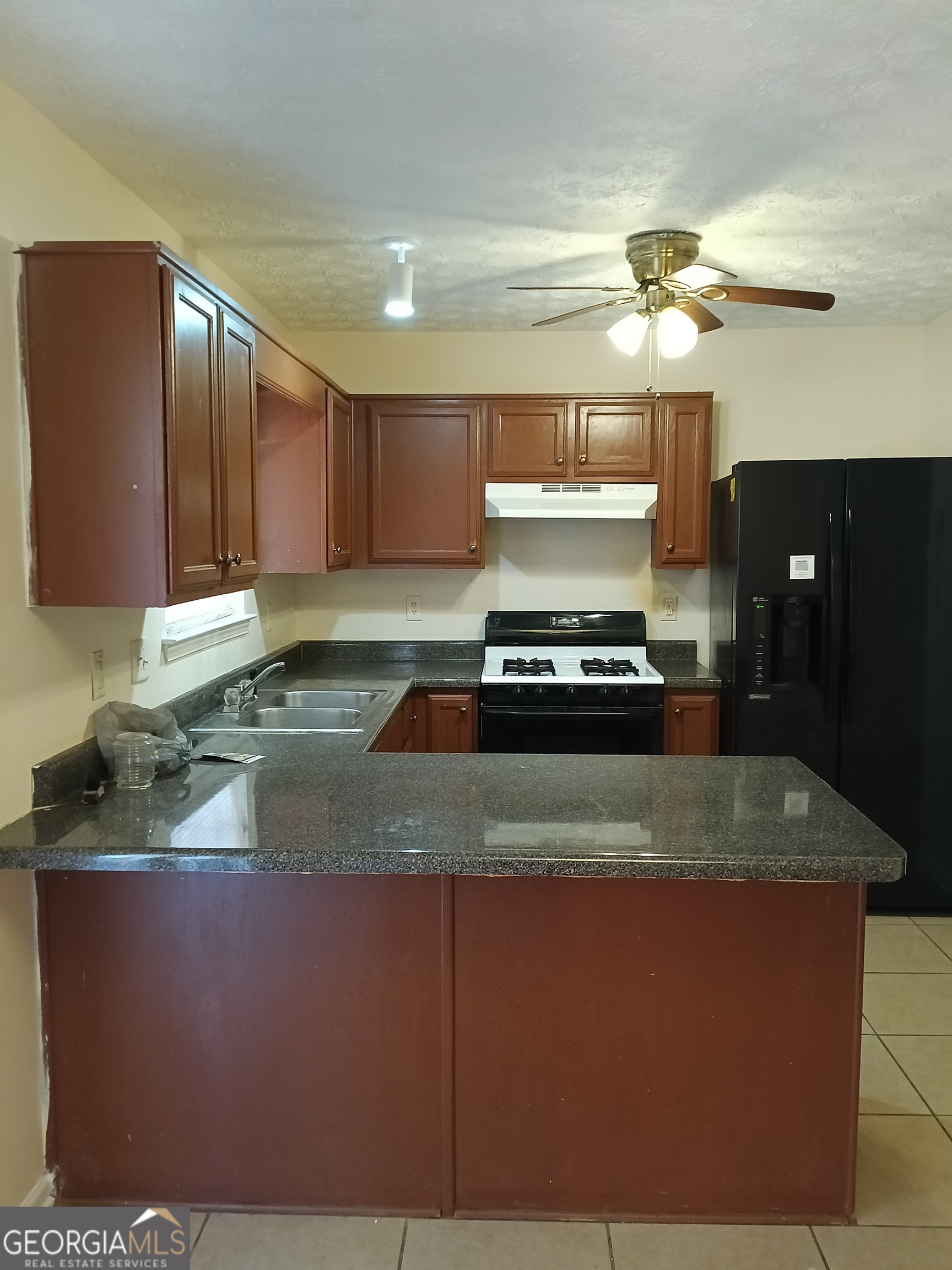 3049 Fields Drive Lithonia, GA 30038 - Photo 4 of 14 a kitchen with kitchen island granite countertop a sink a counter top space and cabinets