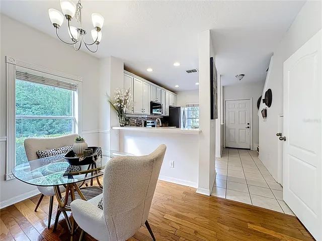 a view of a dining room with furniture a chandelier and wooden floor