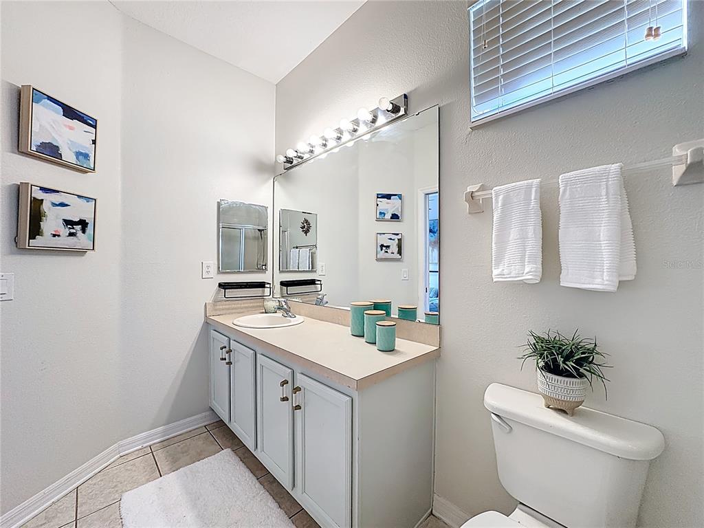 10300 Manderley Way, Unit 119 Orlando, FL 32829 - Photo 24 of 42 a spacious bathroom with a toilet sink and mirror