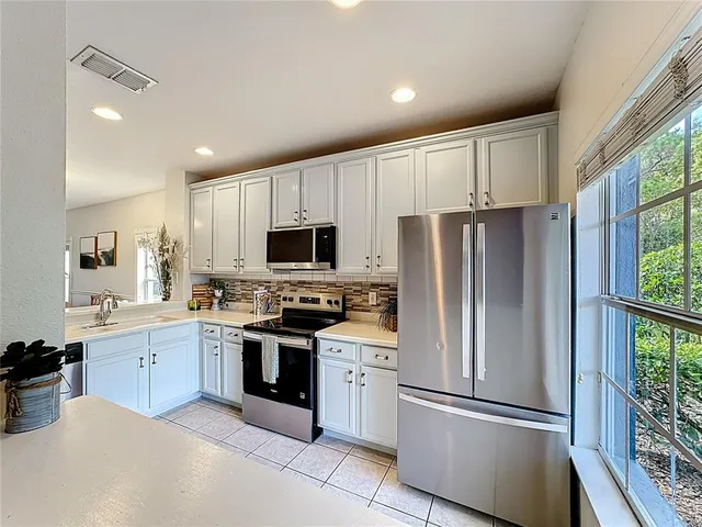 a kitchen with white cabinets and stainless steel appliances