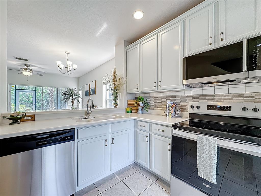 10300 Manderley Way, Unit 119 Orlando, FL 32829 - Photo 7 of 42 a kitchen with a sink stove and microwave