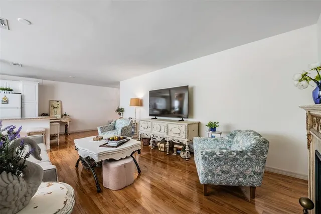 a living room with lots of furniture and a dining table with wooden floor