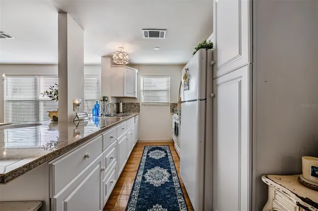 a kitchen with stainless steel appliances granite countertop a refrigerator and a sink