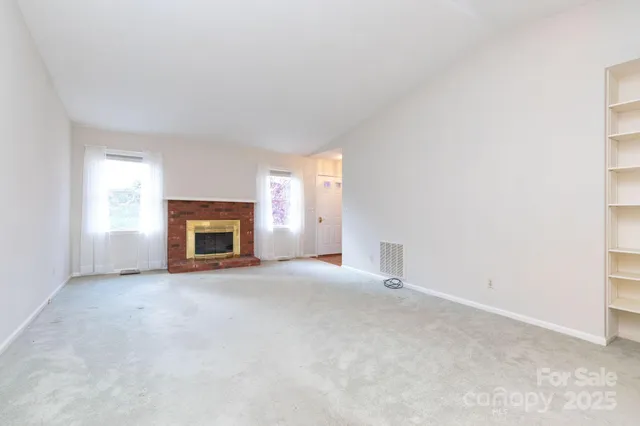 an empty room with a fireplace and window