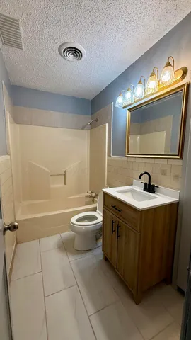 a spacious bathroom with a double vanity sink a toilet and a mirror