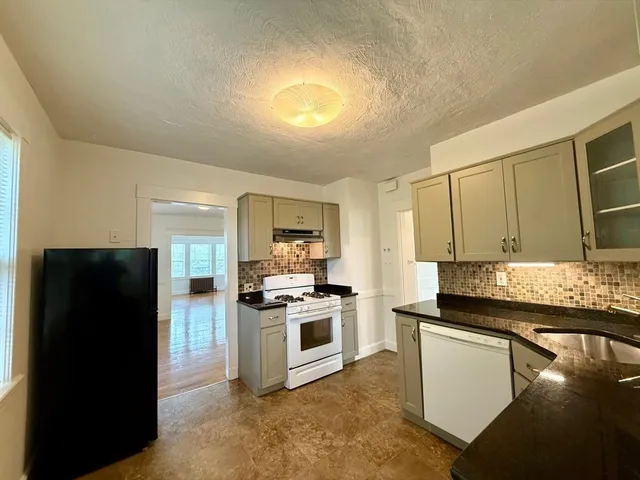a kitchen with a refrigerator and a stove top oven