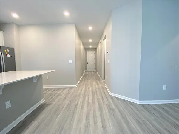 wooden floor in an empty room with wooden floor and a bathroom