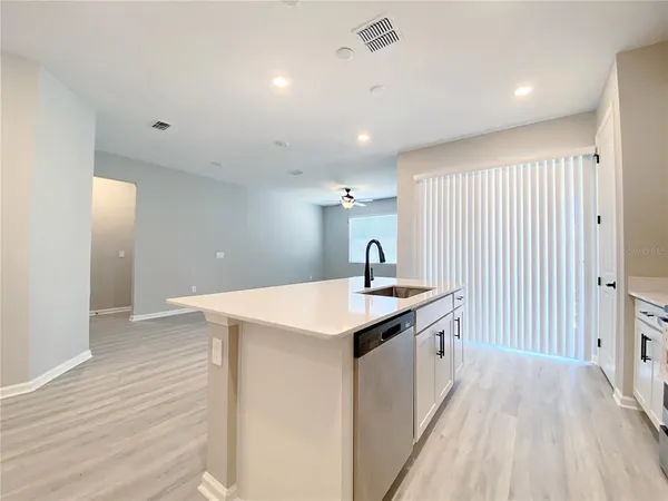 an empty room with windows and ceiling fan