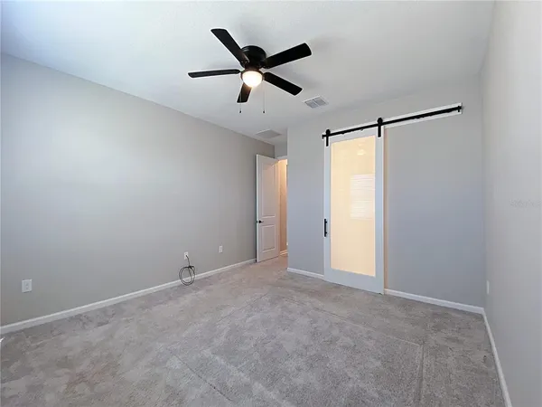 a view of empty room with ceiling fan