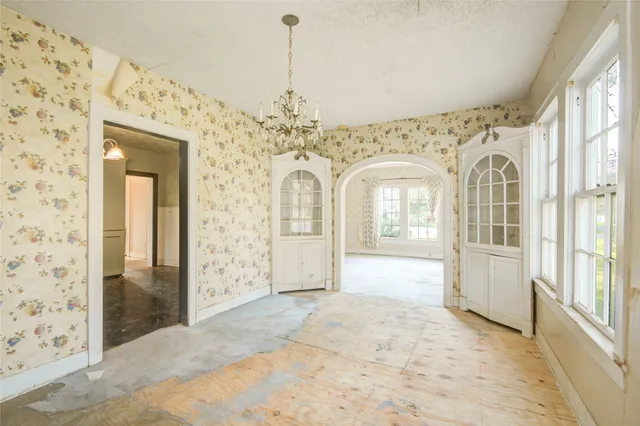 a view of a hallway with windows and chandelier