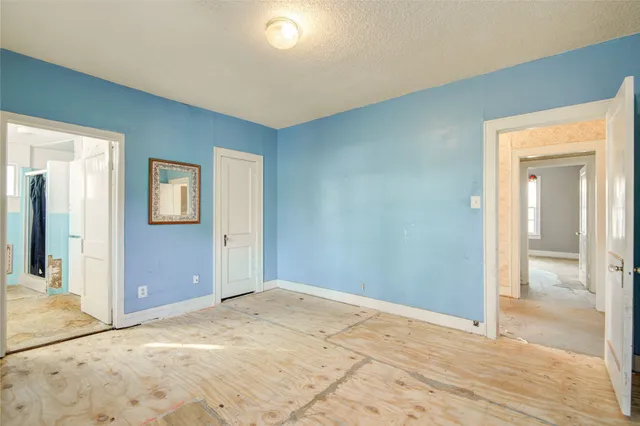 a view of a big room with wooden floor and bathroom