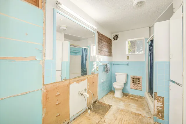 a spacious bathroom with a granite countertop sink a toilet and a mirror