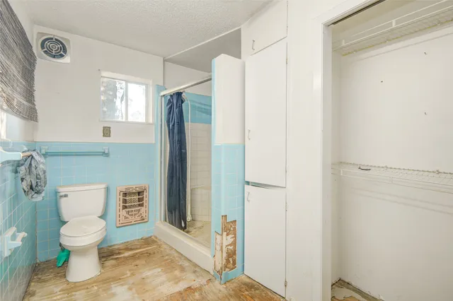 a bathroom with a toilet and a shower