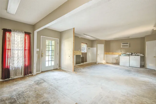 an empty room with windows and bathroom