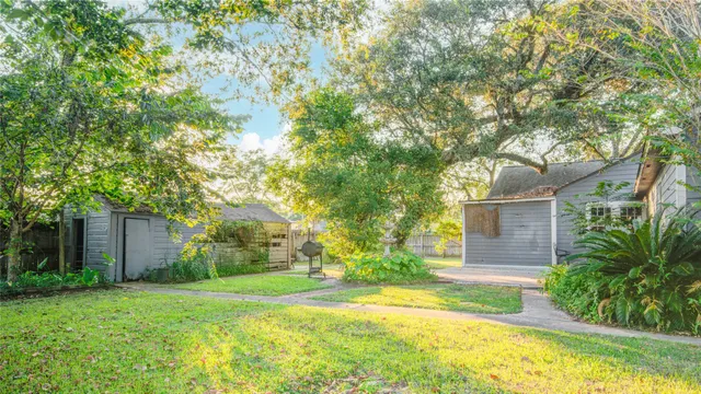 front view of house with a yard and trees all around