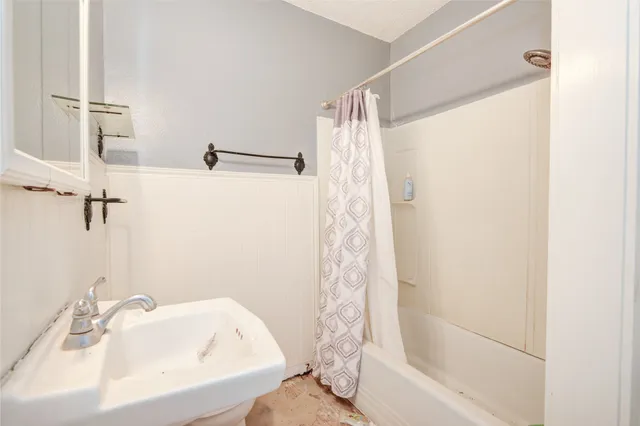 a bathroom with a shower curtain and a sink