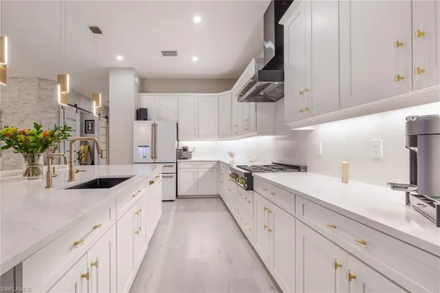 a kitchen with granite countertop white cabinets and white appliances