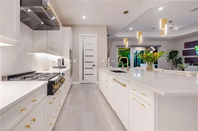 a large kitchen with stainless steel appliances and white cabinets