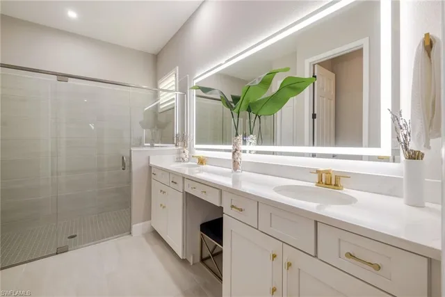 a bathroom with a double vanity sink mirror and shower