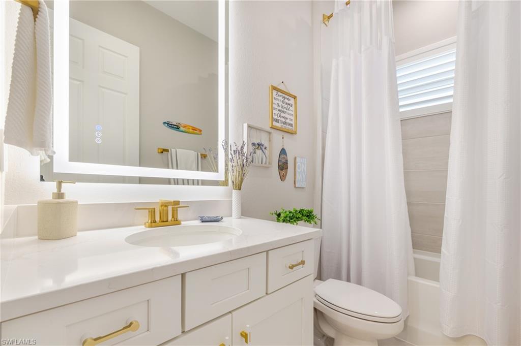 13543 Blue Bay Circle Fort Myers, FL 33913 - Photo 22 of 45 a bathroom with a sink a toilet and shower curtain