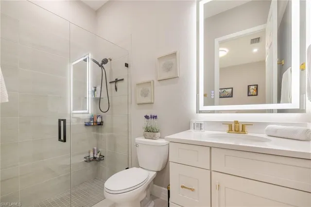 a bathroom with a sink toilet vanity and shower