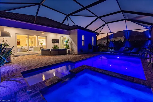 a view of swimming pool with red chairs under an umbrella