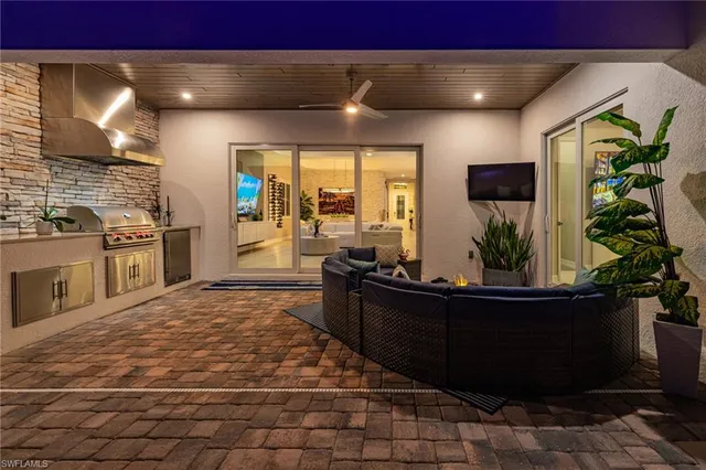 a living room with stainless steel appliances kitchen island granite countertop furniture a rug and a wooden floor