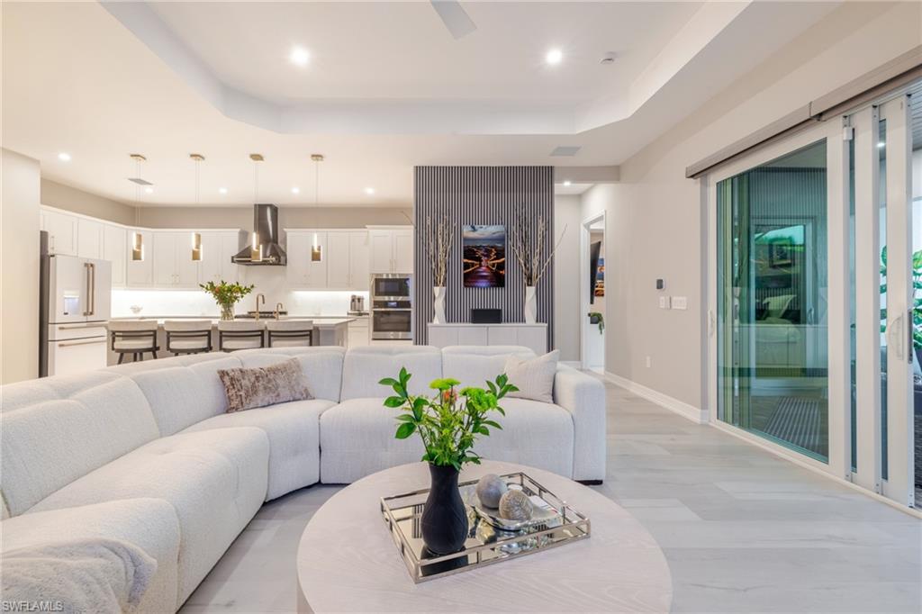 13543 Blue Bay Circle Fort Myers, FL 33913 - Photo 7 of 45 a living room with kitchen island furniture and a chandelier