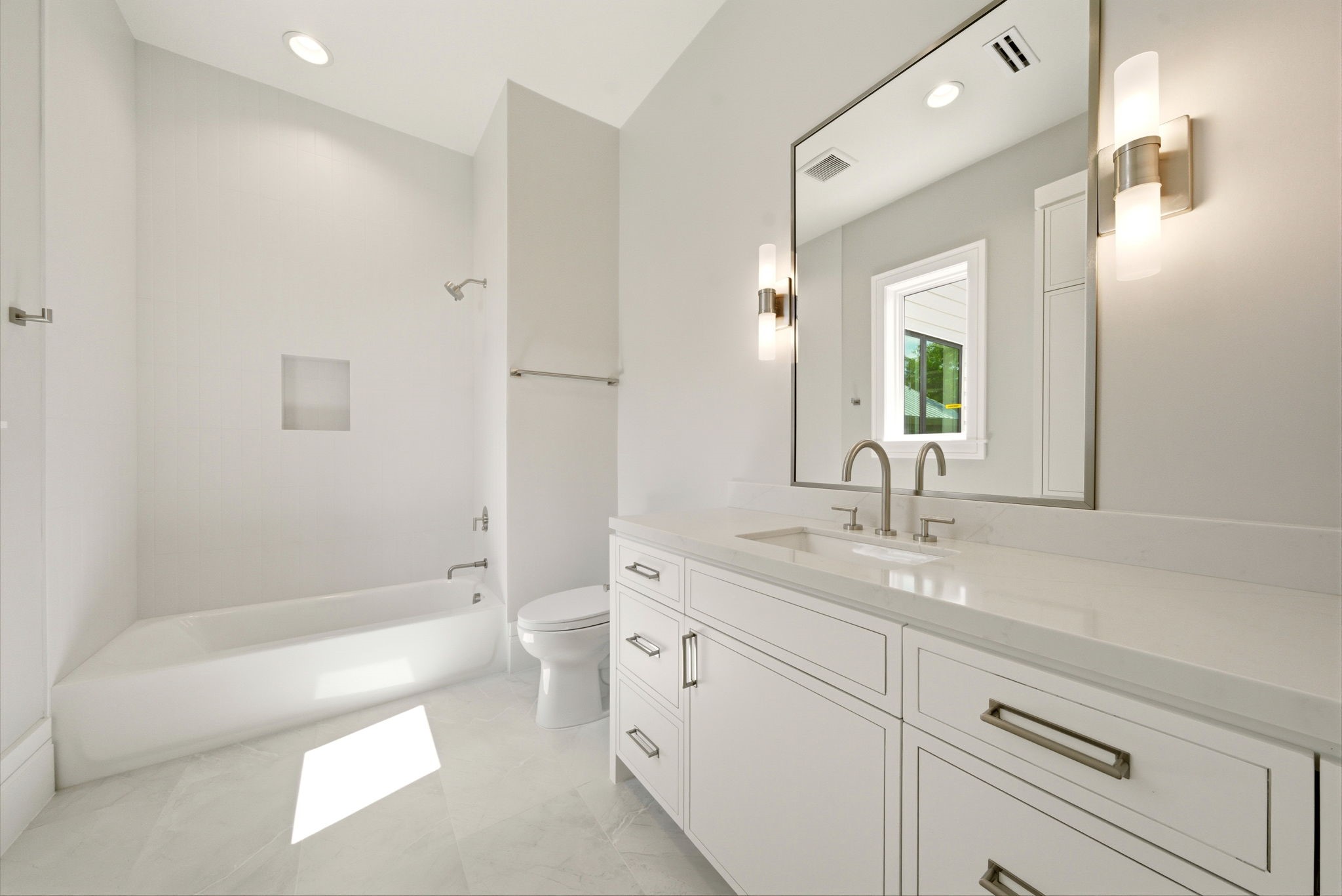 1023 Euclid Street Houston, TX 77009 - Photo 30 of 50 Bright secondary bathroom with quartz countertops, soaking tub/shower combination, and timeless neutral white finishes.