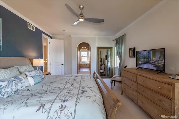 a spacious bedroom with a large bed and a flat screen tv