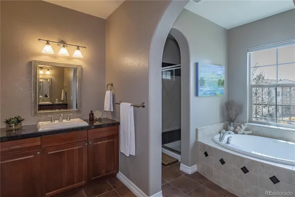 a spacious bathroom with a double vanity sink a mirror and a bathtub
