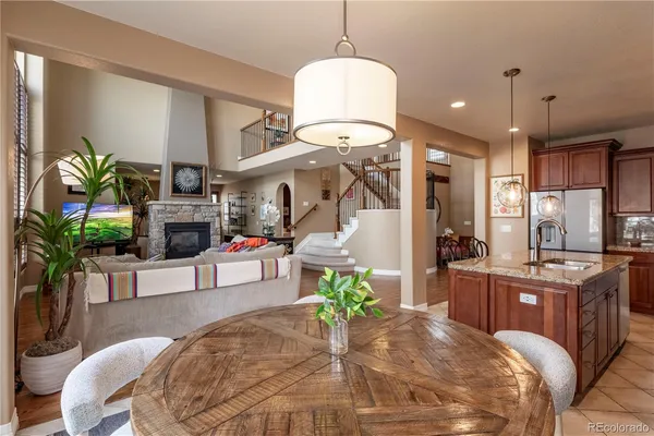 a living room with furniture a chandelier and kitchen view