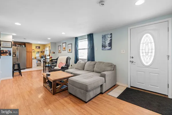 a living room with furniture a table and wooden floor