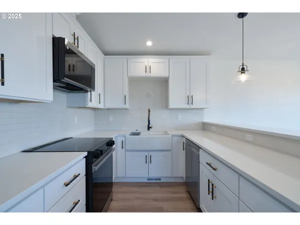 a kitchen with a sink a microwave and cabinets