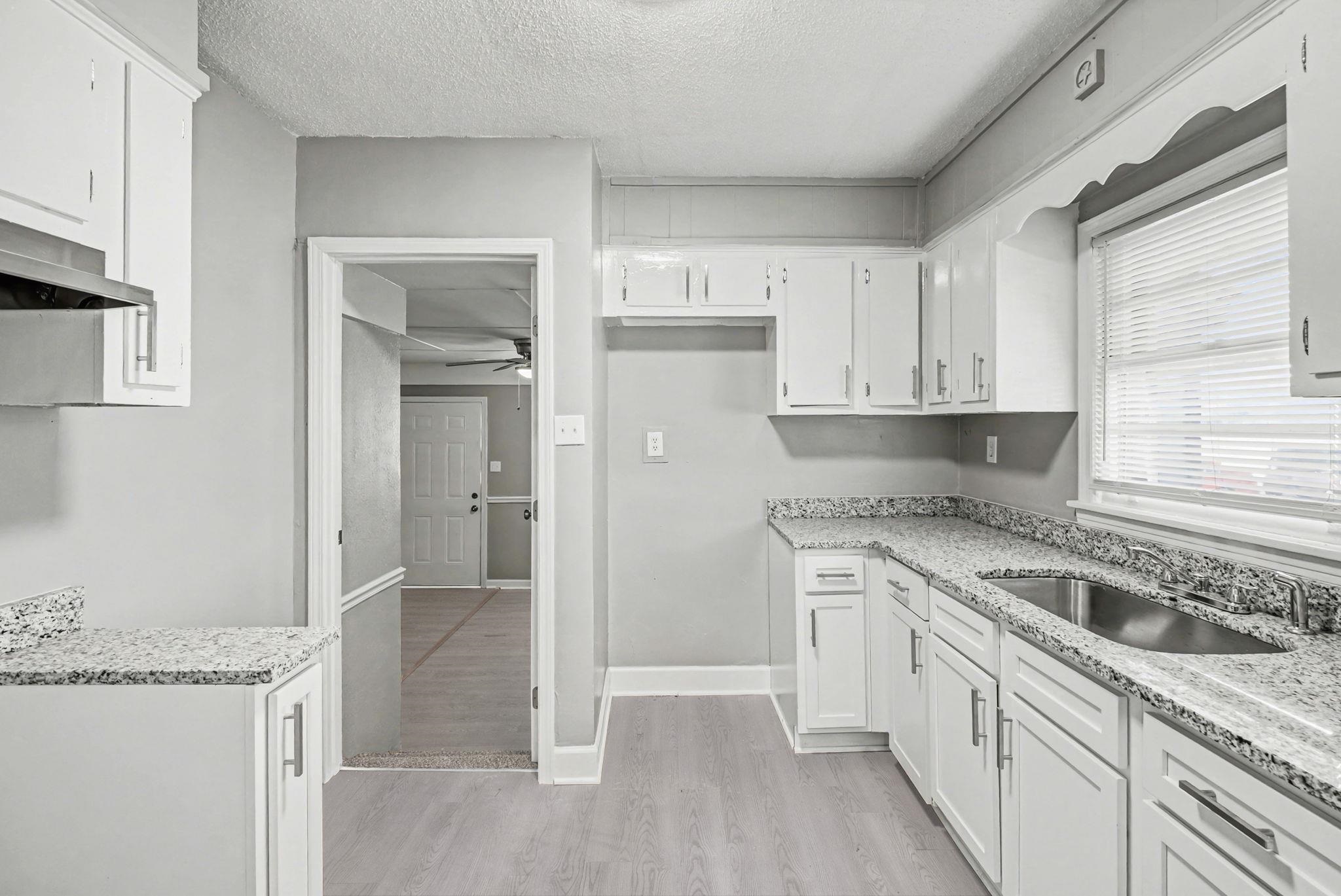 6733 Navy Road Millington, TN 38053 - Photo 19 of 25 a kitchen with granite countertop a sink stove and refrigerator