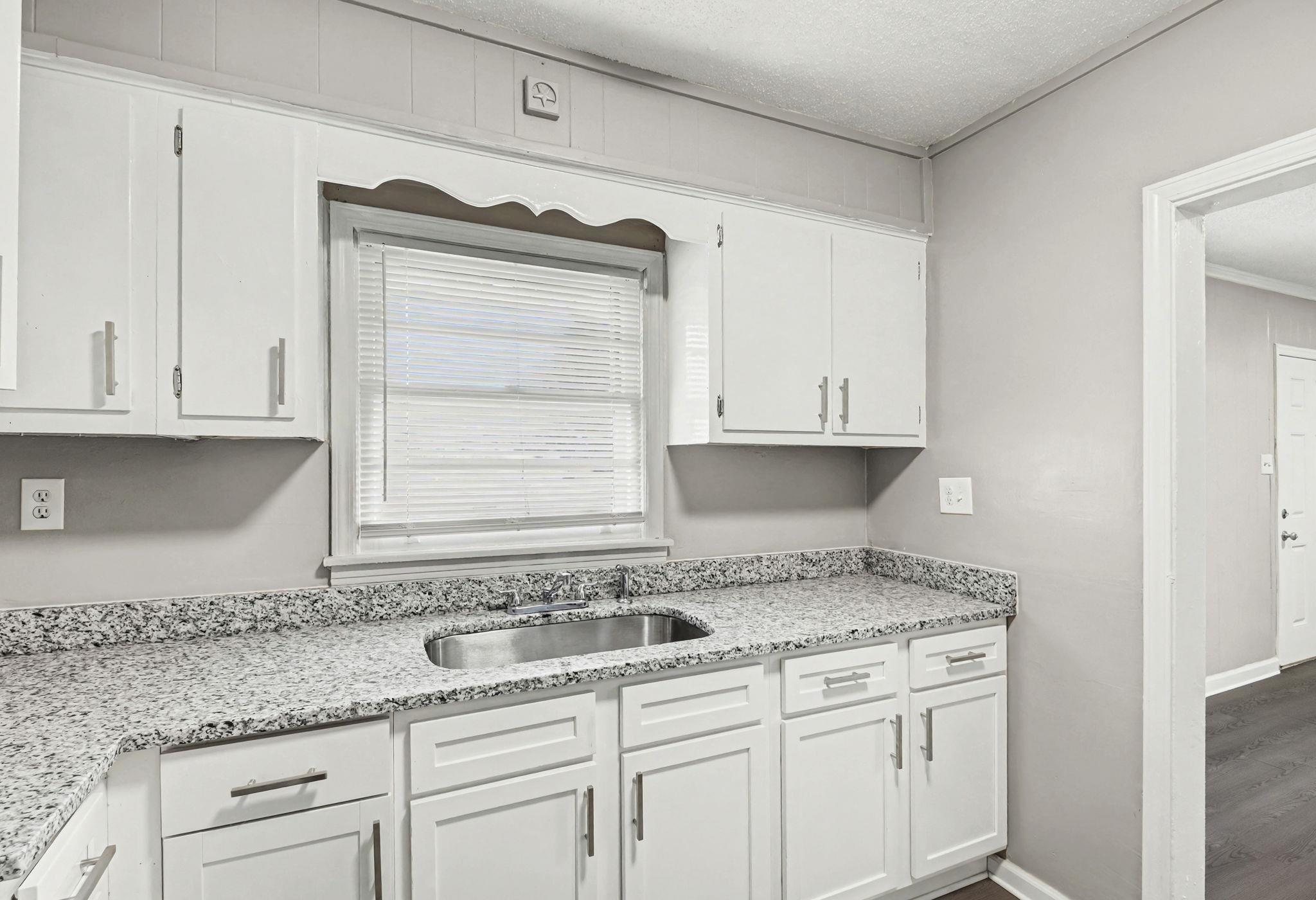 6733 Navy Road Millington, TN 38053 - Photo 21 of 25 a kitchen with granite countertop white cabinets and a sink