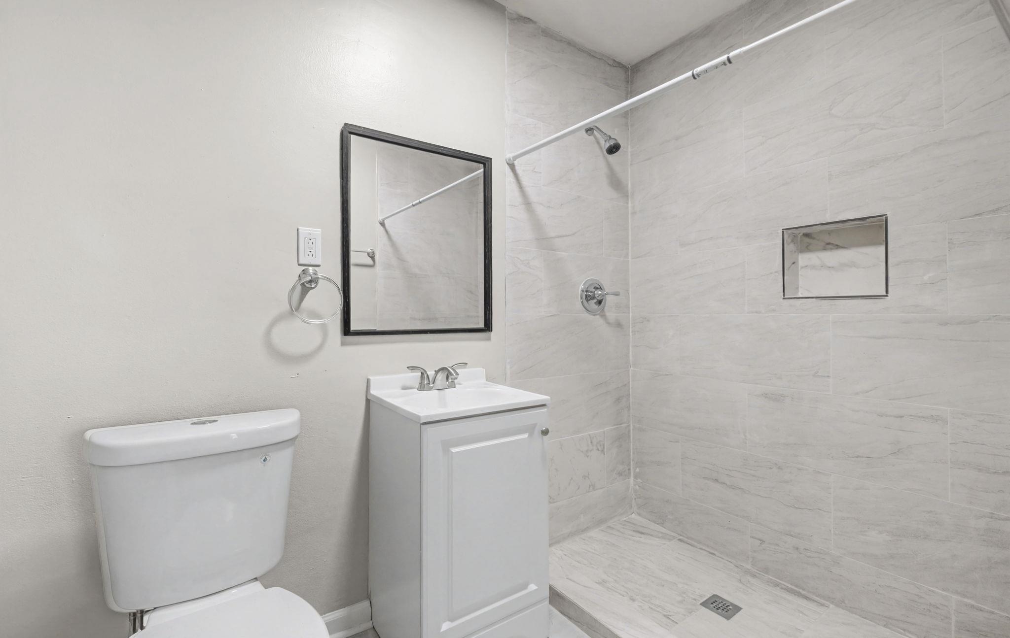 6733 Navy Road Millington, TN 38053 - Photo 3 of 25 a bathroom with a toilet a sink and mirror